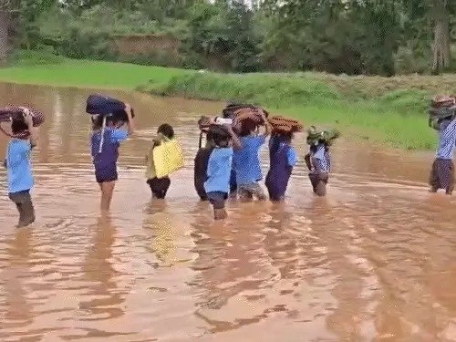गरियाबंद में जलमग्न सड़क से गुजरते स्कूली बच्चे